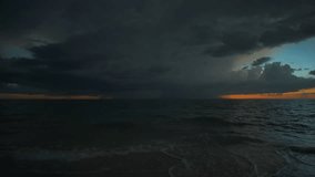 Thunderstorm dark clouds with lightning and thunder over evening sea water waves crushing on sandy beach. Beautiful seascape at sunset - Powered by Shutterstock - Get 15% off with code: PIKWIZARD15