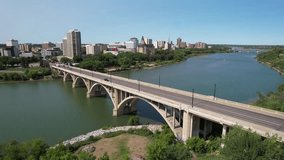 Aerial video of Saskatoon's downtown central business district, SK, Canada. Skyline view reveals bustling urban life, commercial buildings, and roads. Ideal for business concepts.