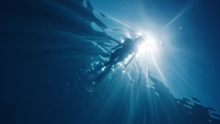 Woman swim in the sea. Underwater view of the woman snorkeling on the surface at sunny calm day