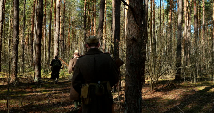 Re-enactors Dressed As Russian Soviet Infantry Red Army Soldiers Of World War II Marching Along Forest In Spring Autumn. Group of Soldiers Marching.