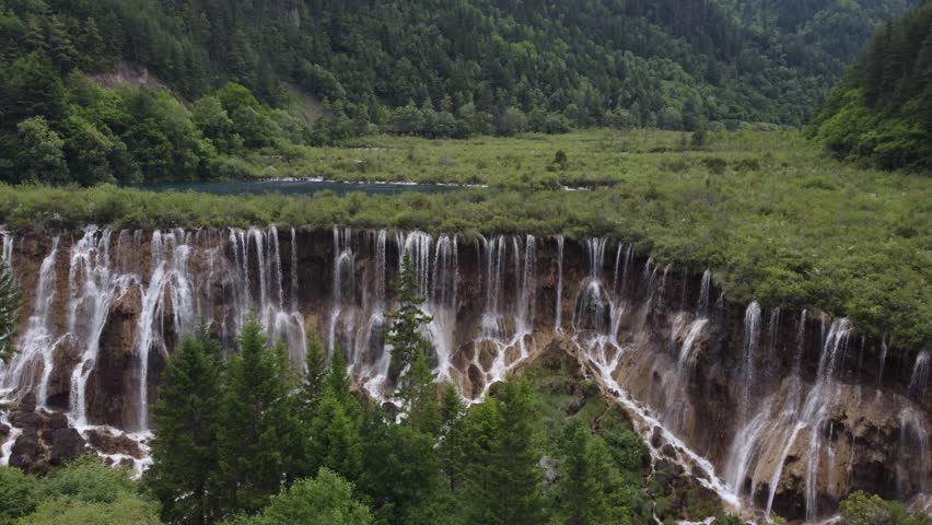 Aerial view of Jiuzhaigou National Park in Sichuan Province China. It features cascading waterfalls, turquoise blue lakes, and stunning mountain valleys. 