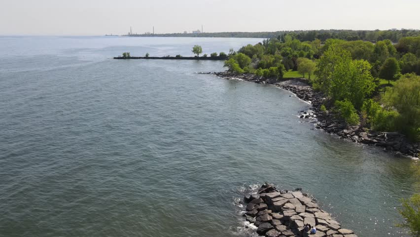 Drone footage of bay of Ontario lake in Mississauga at summer. Green foliage and blue water.