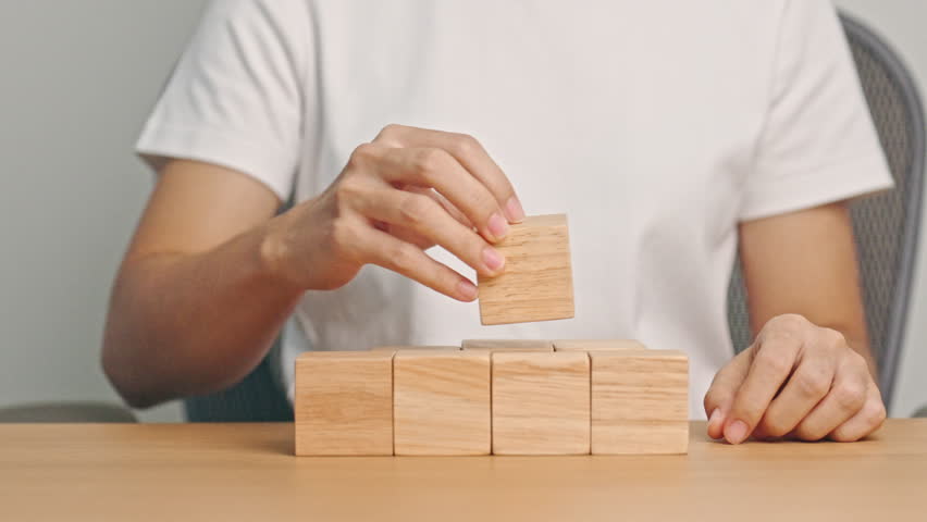 hand placing or pulling wooden block on the building. Business planning, Risk Management, Solution and strategy Concepts