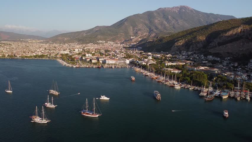 Awesome aerial view of Fethiye Bay in Turkey. Drone flying over the sea. The town is visible on scenic mountains background. Fethiye is a popular tourist destination in the Turkish Riviera. Royalty-Free Stock Footage #1107513903