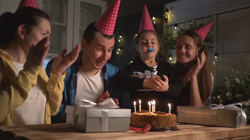 father blows out candles. family celebrating birthday. cake with candles. father blows out candles on birthday cake. Happy family at table in decorated kitchen during birthday celebration Royalty-Free Stock Footage #1107515845