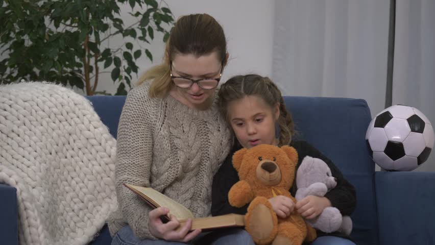 Happy family. Girl with toys listens to mom