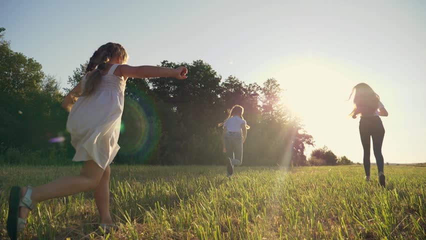 family with children runs on green grass in meadow. happy children behind crowd run to sun. cheerful children rest. Happy family running on grass at sunset. Group of happy children in park outdoor Royalty-Free Stock Footage #1107515887
