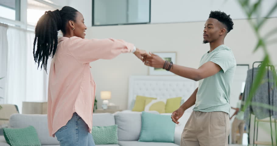 Love, dancing and happy black couple in living room together for care, happiness and bonding to music in home. Romantic, man and woman enjoy quality time in an intimate moment with trust in apartment Royalty-Free Stock Footage #1107519569