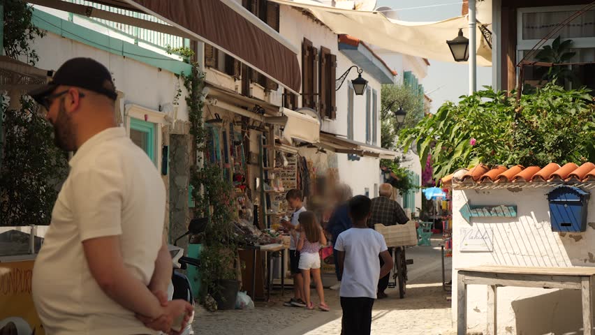 the camera flies along the street of the old city people walk along the houses