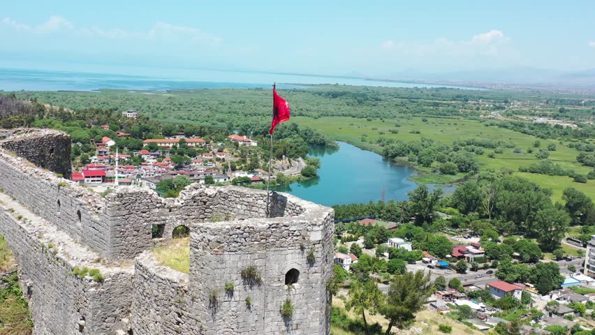 aerial panoramic of Rozafa Castle or Shkoder Castle, in shkodra, northwestern Albania. drone view of waving albania flag Royalty-Free Stock Footage #1107520769
