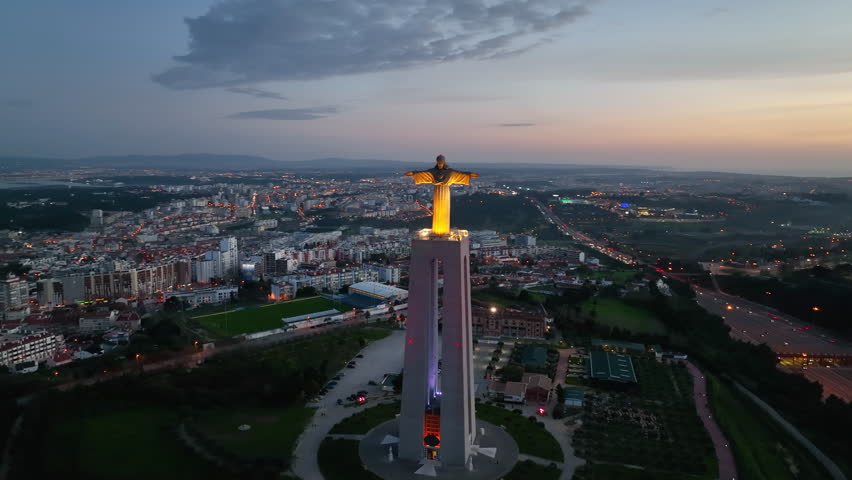 Drone flight around the statue of Jesus Christ in Lisbon. Jesus monument in sunset light.