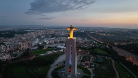 Drone flight around the statue of Jesus Christ in Lisbon. Jesus monument in sunset light.