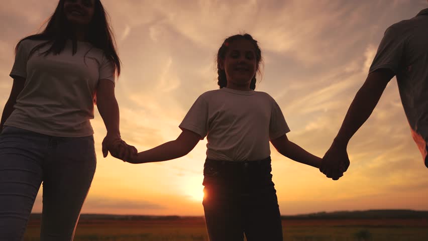 A family of three walks in the park at sunset. happy family kid dream concept. mom dad and daughter have a great time together. friendly walk in a lifestyle beautiful place at sunset | Shutterstock HD Video #1107521055
