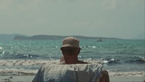 Corfu island, Greece - 2023.07.01 - 09: Elderly man enjoying a book on a sunbed at the beautiful beach, under the hot, sunny blue sky, with gentle waves in the blue water background - Powered by Shutterstock - Get 15% off with code: PIKWIZARD15