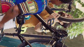 Vertical video Dedicated multiethnic couple repairing bicycle parts with specialized tools in home yard. Sporty girlfriend and boyfriend using professional equipment for bike components adjustment.