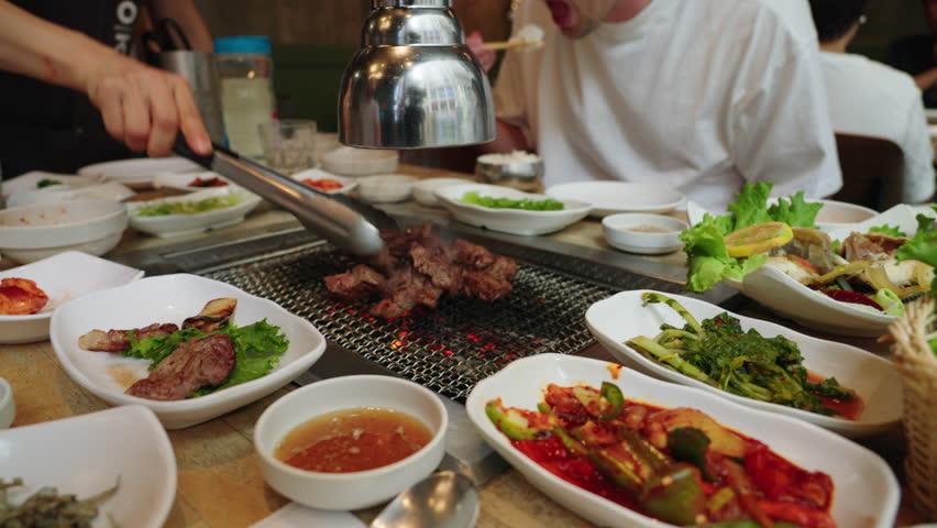 Korean barbecue is cooked and served at a restuarant. Royalty-Free Stock Footage #1107529605