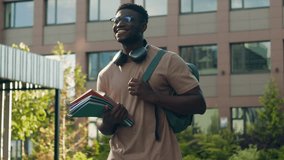 African American happy smiling student guy ethnic university man male with backpack school bag and books smile walking in city outdoors in academy college university campus on education class lesson - Powered by Shutterstock - Get 15% off with code: PIKWIZARD15