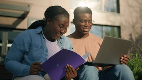 Two friends African American ethnic students woman man girl guy discuss homework university prepare for exams together with computer talking in city studying education with laptop study book outdoors - Powered by Shutterstock - Get 15% off with code: PIKWIZARD15