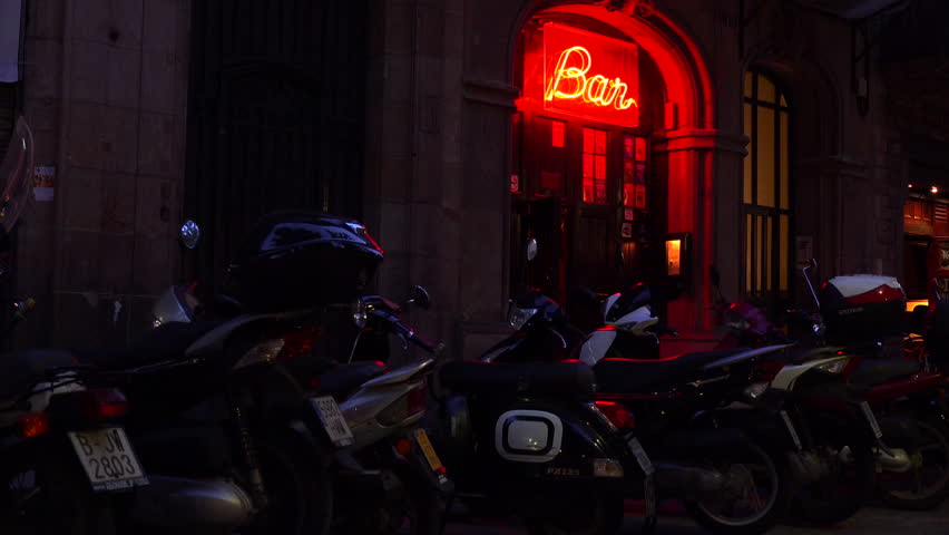 Barcelona, spain - 2023 - exterior of a generic bar with a neon sign at night with motorbikes in front. Royalty-Free Stock Footage #1107530631