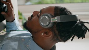 Focused dj playing music remotely vertical closeup. African american headphones man working disc jockey midi controller at home. Black hair freelancer create song. Digital audio technology for mixing  - Powered by Shutterstock - Get 15% off with code: PIKWIZARD15