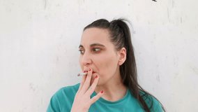 Close-up perspective video of a girl's face while she is smoking a cigarette