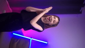 
Woman influencers streaming share dancing content, stories popular trendy dance on social media with neon lights. Bloggers shooting created her dancing vertical video for social network on smartphone