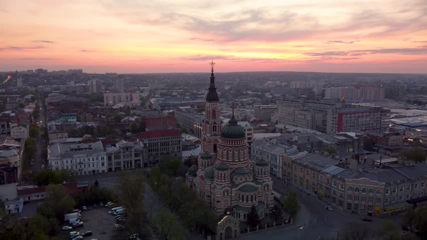 Arc above Holy Annunciation Cathedral with evening sunset scenic cloudscape. Aerial view Kharkiv city orthodox church in downtown, Ukraine