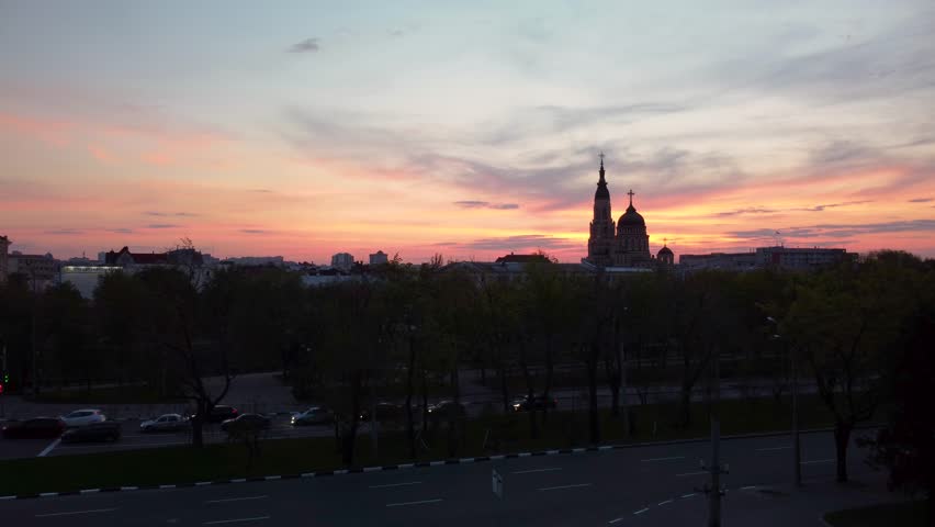 Fly forward to Holy Annunciation Cathedral with evening purple and orange sunset scenic cloudscape. Aerial view Kharkiv city orthodox church in downtown, Ukraine