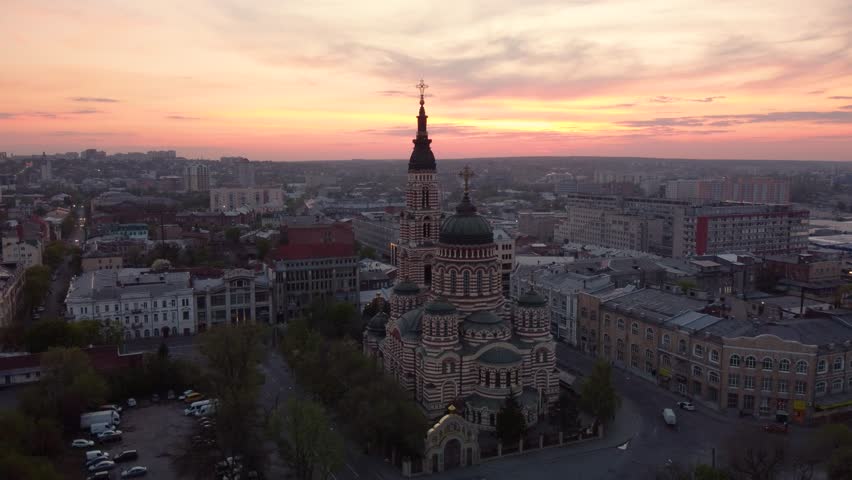 Fly up above Holy Annunciation Cathedral with evening sunset scenic cloudscape. Aerial view Kharkiv city orthodox church in downtown, Ukraine