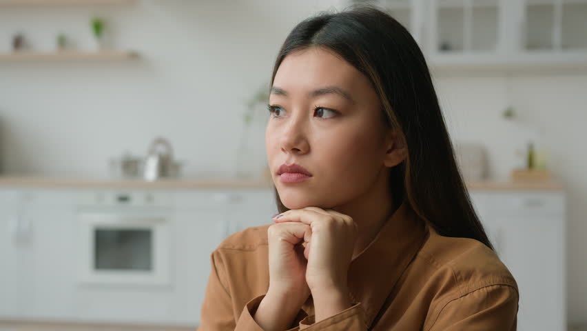 Sad depressed female portrait pensive worried alone Asian girl chinese korean japanese woman suffer loneliness problem hope think deep worry breakup grief melancholy depression sadness at home kitchen Royalty-Free Stock Footage #1107549697