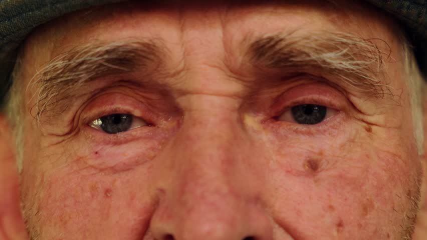 Tired eyes of a senior caucasian man. Close-up of an elderly wrinkled man's eyes. Wise look of an old grandfather. Grandparents day concept. Royalty-Free Stock Footage #1107556295