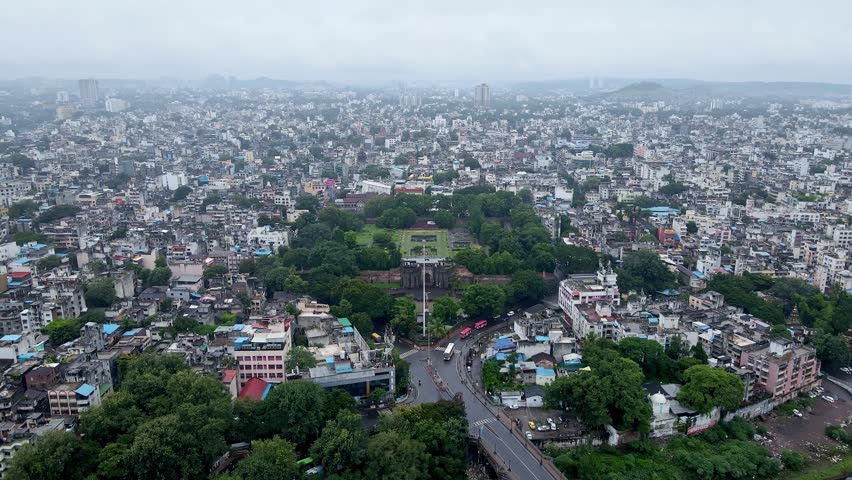 Aerial footage of Shaniwar Wada, a fortification in Pune city, India with busy roads and building roof tops in monsoon season. Indian city aerial with historic and modern architecture. Pune drone Royalty-Free Stock Footage #1107561199