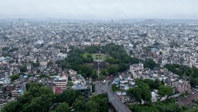 Aerial footage of Shaniwar Wada, a fortification in Pune city, India with busy roads and building roof tops in monsoon season. Indian city aerial with historic and modern architecture. Pune drone