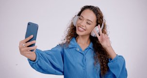 Woman, peace or headphones for selfie in studio, live streaming or video call on white background. Profile picture, happy gen z model and v sign with tongue out, blowing kiss or emoji on social media
