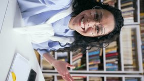 POV Webcam view. Vertical video. Female student talking on a video call using a smartphone in campus library space. Happy positive girl having conversation with friend while taking selfie in classroom - Powered by Shutterstock - Get 15% off with code: PIKWIZARD15