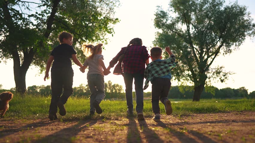 children run holding hands. happy family. silhouette group of children at sunset run through the park in nature. happy lifestyle family kid dream concept. happy kids running together silhouette Royalty-Free Stock Footage #1107573001
