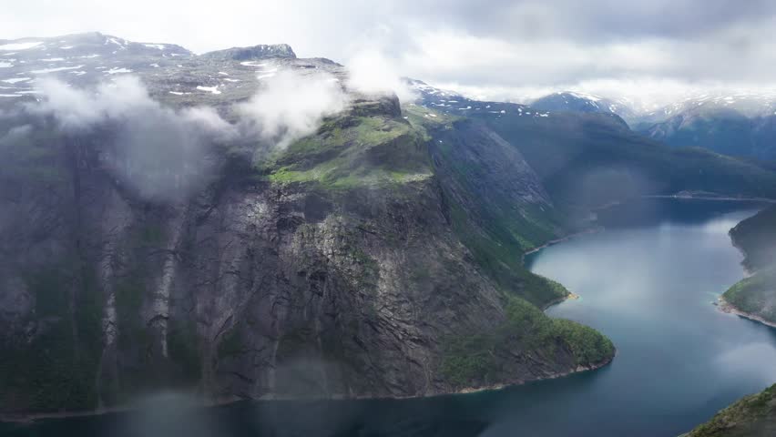 Aerial view over Norwegian Fjord and Mountains on cloudy day . High quality 4k drone footage.