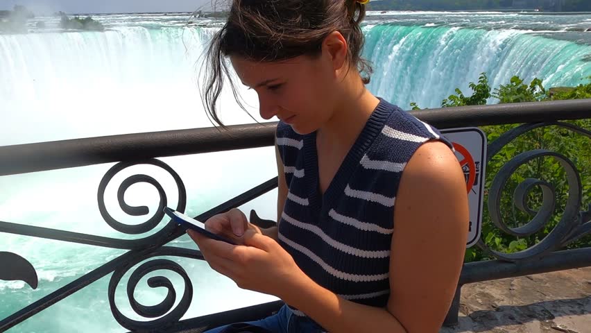 A Beautiful Young Woman Texting while on Vacation.