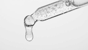 Closeup cosmetic serum fluid gel with bubbles from dropper, pipette over white - Powered by Shutterstock - Get 15% off with code: PIKWIZARD15