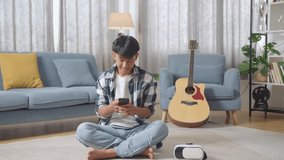 Full Body Asian Teen Couple, A Girl Coming Home Surprising Her Boyfriend Who Sits On The Floor Playing Smartphone
