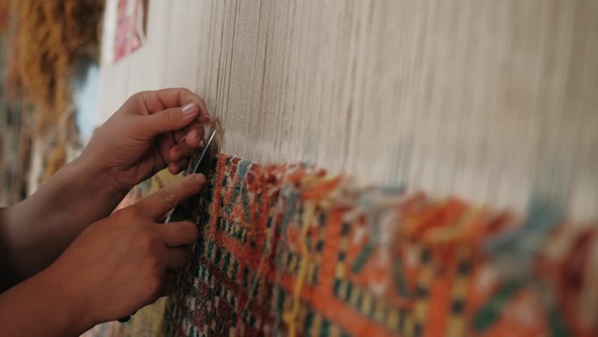 Woman weaves a traditional Arabic carpet of multicolored wool. Weaving and making handmade carpets close-up. Needlework. Handcraft. Royalty-Free Stock Footage #1107604561
