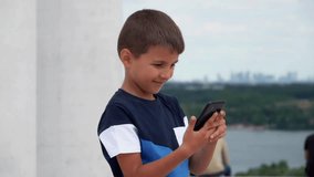 Smiling boy looking at smartphone. High quality FullHD footage