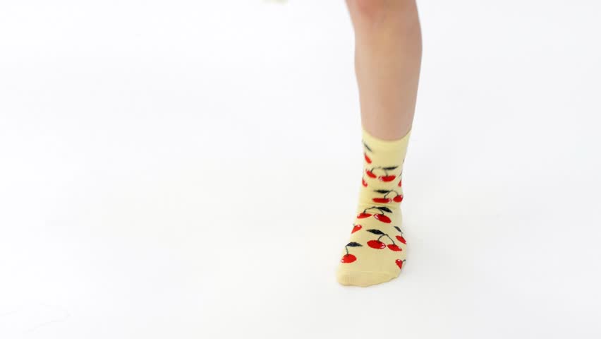 Studio shot of teenage girls socks with cherries. The girl dances by turning the soles of her feet left and right. Suitable for music. Ancient energetic dances. Cardio and fitness. Royalty-Free Stock Footage #1107606253