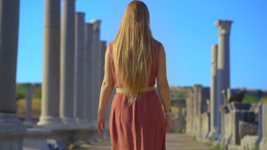 A young woman visits the remarkable ruins of the ancient city of Perge in conteprorary city of Antalya, Turkey. The ruins stand as a testament to the city