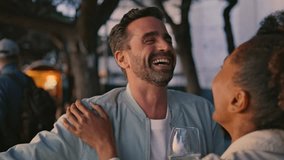Laughing lovers having fun at evening bar rooftop close up. Two multiracial people joking at romantic meeting in cafe terrace. Lovely pair enjoying love relationship spending happy moments together - Powered by Shutterstock - Get 15% off with code: PIKWIZARD15