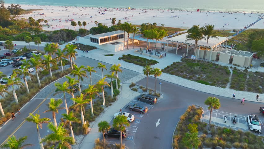 Parking lot for tourists cars in front of famous Siesta Key beach with soft white sand in Sarasota, USA at sunset. Popular vacation spot in warm Florida