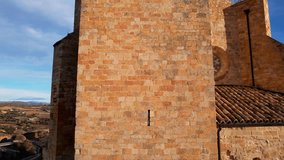 Aeriel drone view of tower of church in Benabarre, in enclosure of old medieval castle of benabarre, built in stone, two bells and two cornices ancient architecture. Huesca province, Aragon, Spain.4K
