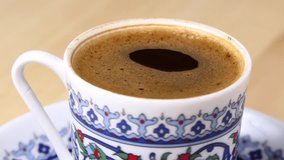 a cup of Turkish coffee rotate on a board. 4k video footage