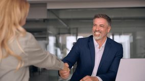 Mature Latin business team of woman and European business man shaking hands as colleagues, partners or employees, signing a contract. Group of people satisfied with results of team work together. - Powered by Shutterstock - Get 15% off with code: PIKWIZARD15