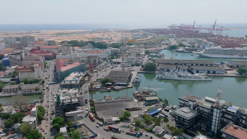Aerial panoramic view of Fort urban borough with heavy traffic on roads and large cargo terminal in seaport in background. Colombo, Sri Lanka
